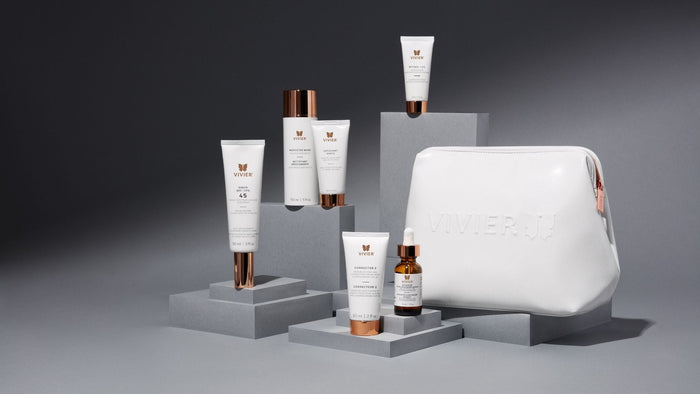 Selection of Vivier skincare products displayed on grey pedestals alongside a white Vivier cosmetic bag.