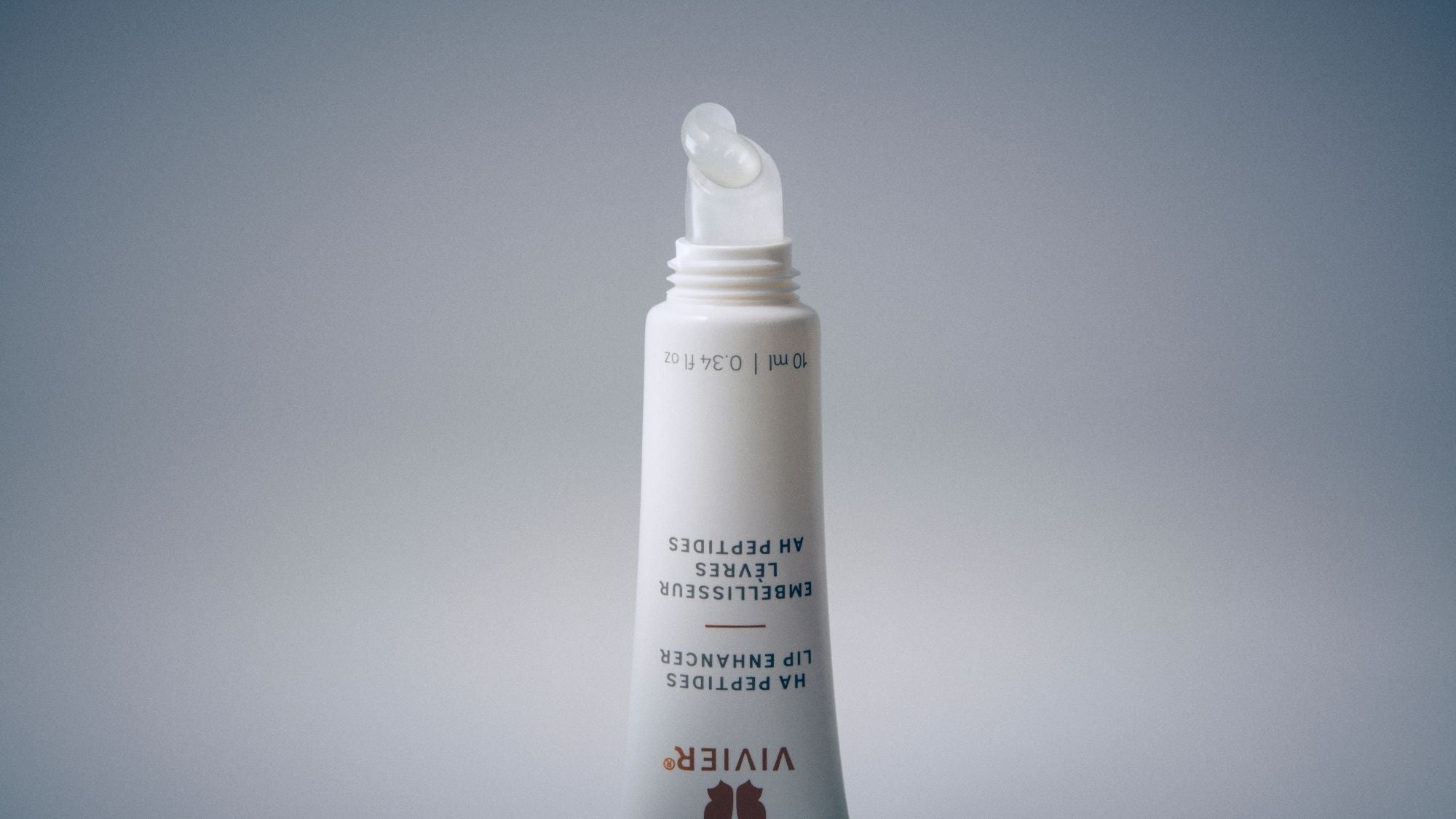 Close-up of a Vivier HA Peptides Lip Enhancer tube with a clear gel formula dispensed from the applicator.